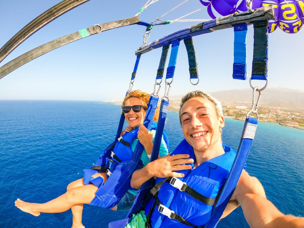 close-up-and-selfie-of-two-happy-people-together-flying-with-a-kite-in-the-middle-of-the-sea.jpg